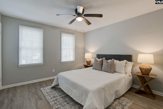 bedroom with wood finished floors, baseboards, and ceiling fan