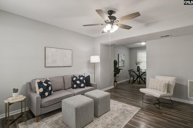 living area featuring baseboards, ceiling fan, and wood finished floors
