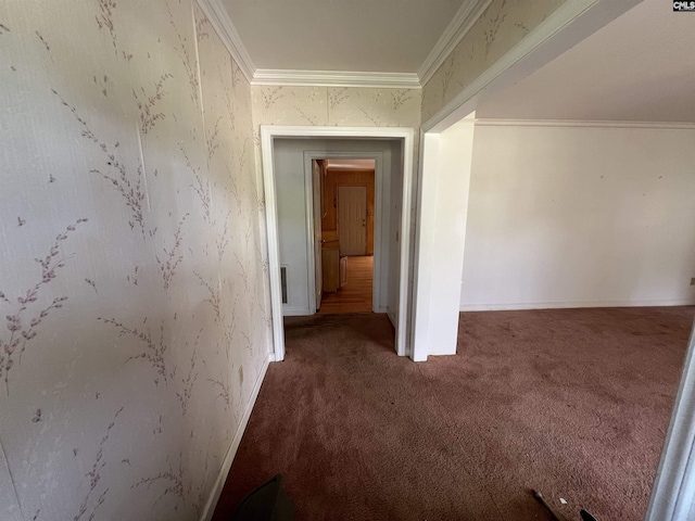 corridor with carpet flooring, ornamental molding, and baseboards