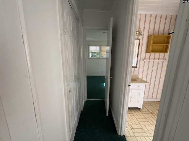 hall featuring brick patterned floors and baseboards
