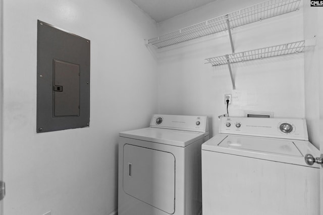 clothes washing area with electric panel and washer and dryer