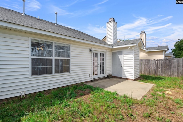 back of property with a patio area, fence, and french doors