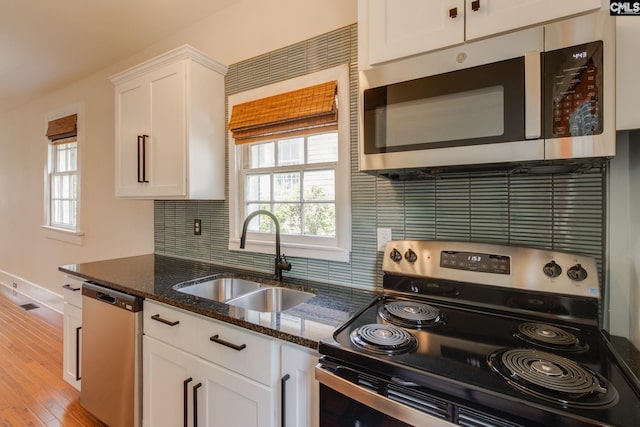 808 Oak St, Columbia, SC 29205 - kitchen with appliances with stainless steel finishes, a sink, white cabinets, dark stone counters, and decorative backsplash