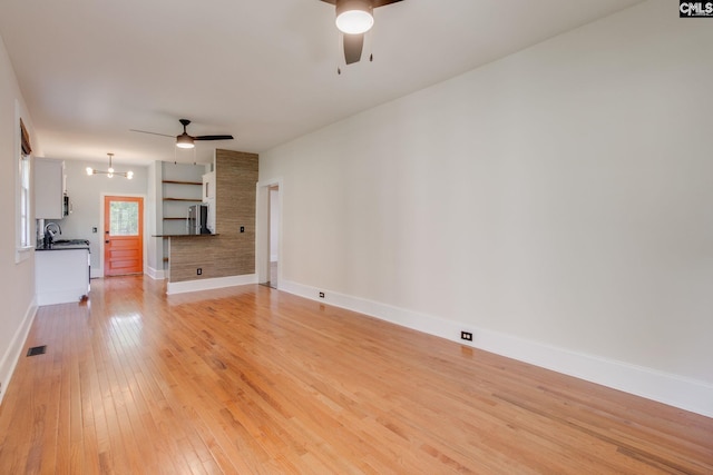 808 Oak St, Columbia, SC 29205 - unfurnished living room with ceiling fan, light wood-style flooring, baseboards, and a chandelier