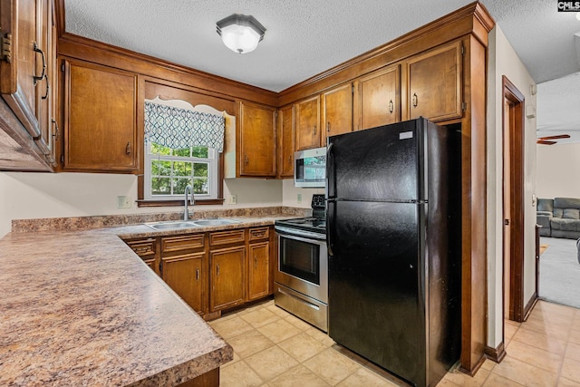 401 Brickling Rd, Irmo, SC 29063 - kitchen featuring stainless steel appliances, a sink, a textured ceiling, brown cabinetry, and light tile patterned floors