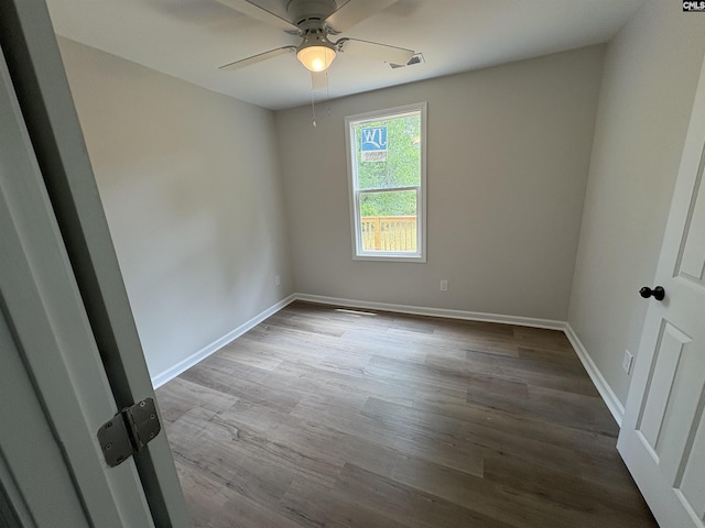 spare room with ceiling fan, wood finished floors, and baseboards