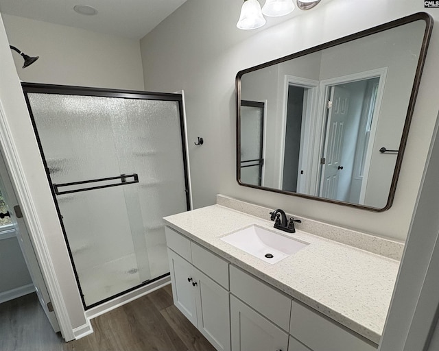 full bath featuring wood finished floors, a shower stall, and vanity