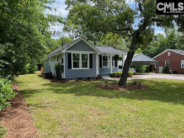view of front of house featuring covered porch, a front lawn, and dirt driveway