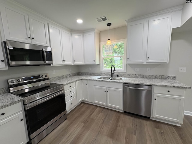 kitchen featuring stainless steel appliances, a sink, dark wood-style flooring, white cabinetry, and recessed lighting