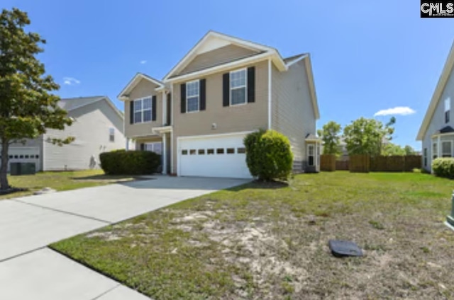 traditional home featuring an attached garage, concrete driveway, and a front yard