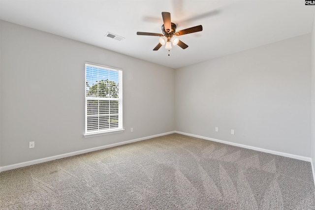 carpeted empty room featuring ceiling fan and baseboards