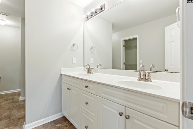 full bathroom with double vanity and baseboards