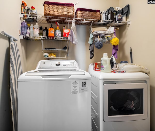 clothes washing area with washing machine and dryer