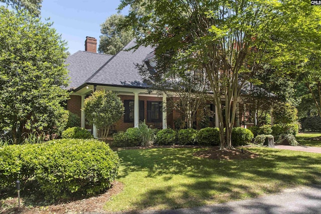3 Puddle Ln, Camden, SC 29020 - view of front of property featuring brick siding, a front lawn, roof with shingles, a chimney, and covered porch