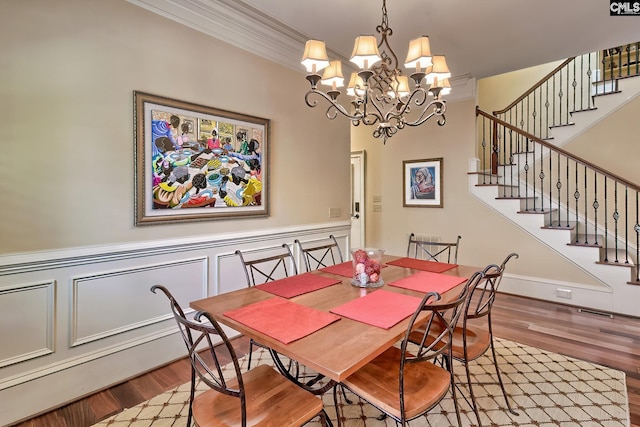 104 Preserve Ln, Columbia, SC 29209 - dining room featuring wood finished floors, a chandelier, a wainscoted wall, ornamental molding, and stairs