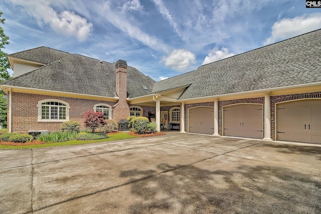 104 Preserve Ln, Columbia, SC 29209 - view of front facade featuring brick siding, roof with shingles, a chimney, a garage, and concrete driveway