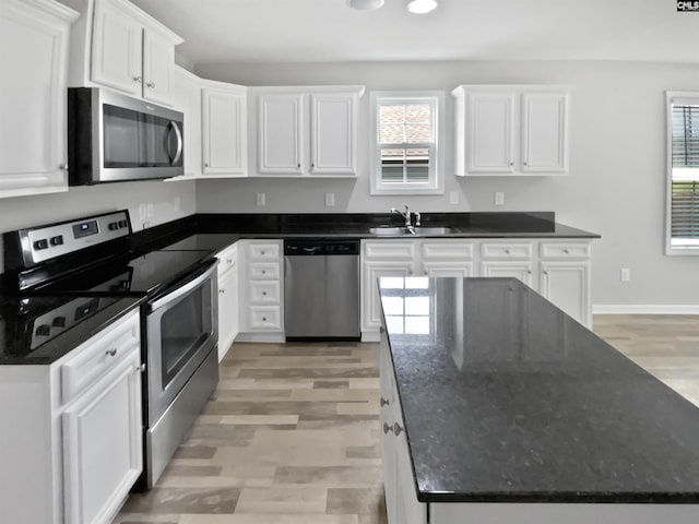 kitchen with stainless steel appliances, plenty of natural light, a sink, white cabinetry, and recessed lighting