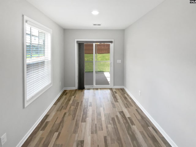 doorway featuring wood finished floors, baseboards, and recessed lighting