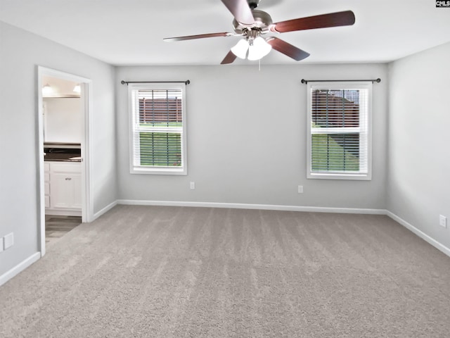 empty room featuring carpet, a ceiling fan, and baseboards