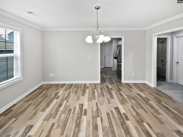 unfurnished dining area featuring a chandelier, baseboards, wood finished floors, and ornamental molding
