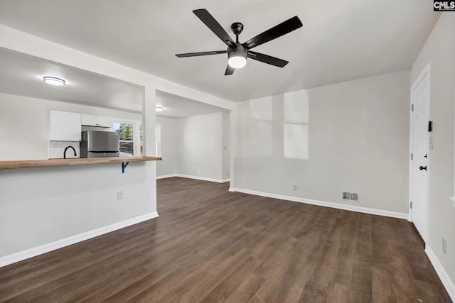 4520 Bluff Rd, Columbia, SC 29209 - unfurnished living room featuring dark wood-style flooring, baseboards, and ceiling fan
