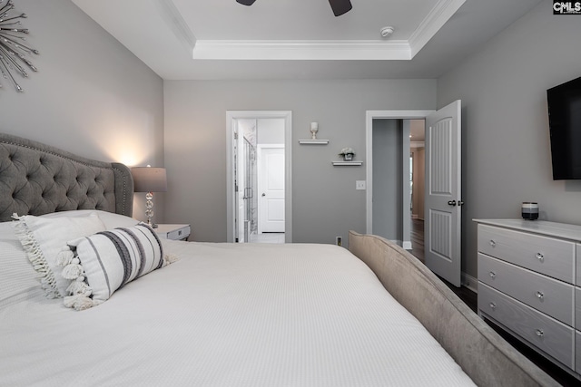 bedroom featuring crown molding, a tray ceiling, connected bathroom, and ceiling fan