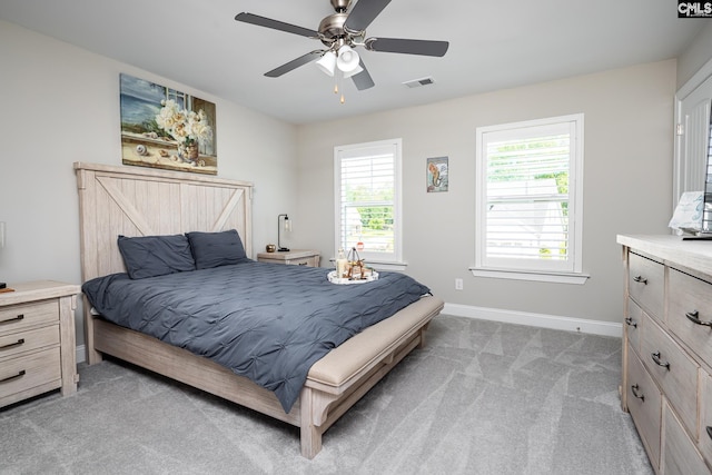 bedroom with light carpet, baseboards, and a ceiling fan