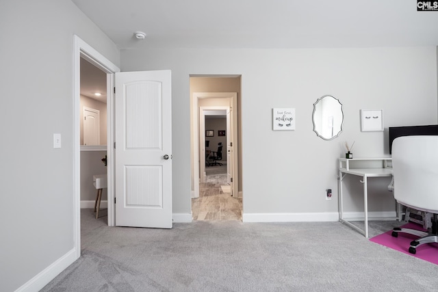 carpeted home office featuring baseboards