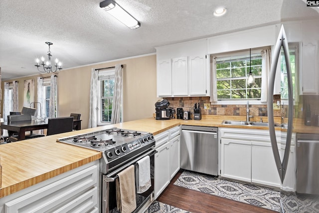 4117 Beecliff Dr, Columbia, SC 29205 - kitchen with dishwasher, gas stove, ornamental molding, a sink, and butcher block counters