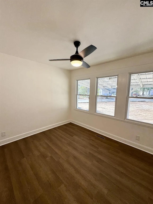 1306 Bonner Ave, Columbia, SC 29204 - empty room with dark wood finished floors, baseboards, and ceiling fan