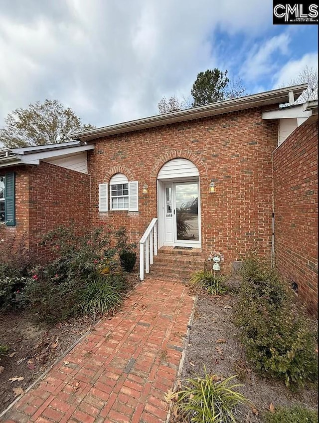 property entrance featuring brick siding