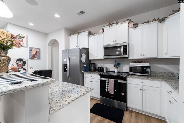603 Rose Quartz Ln, Lexington, SC 29073 - kitchen featuring stainless steel appliances, arched walkways, light wood finished floors, white cabinetry, and recessed lighting