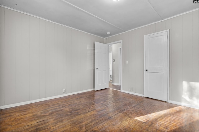 4717 Linden St, Columbia, SC 29203 - unfurnished bedroom with wood-type flooring, baseboards, wooden walls, and crown molding