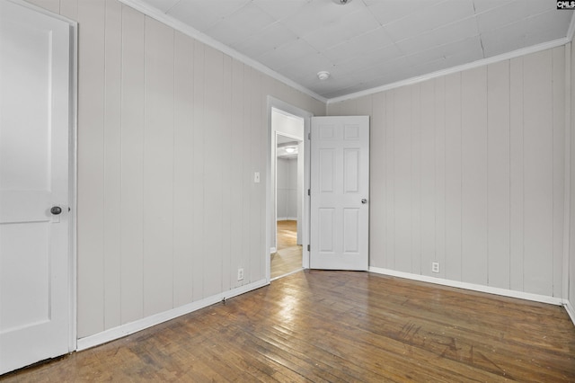 4717 Linden St, Columbia, SC 29203 - unfurnished bedroom featuring wood-type flooring, ornamental molding, baseboards, and wooden walls