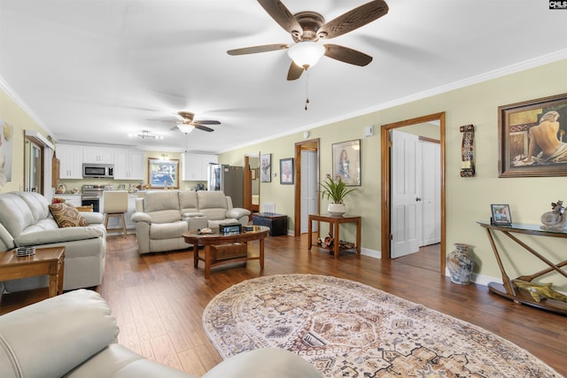 living room with a ceiling fan, crown molding, dark wood-type flooring, and baseboards