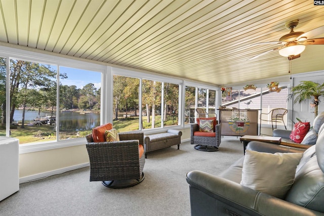 sunroom featuring a water view, healthy amount of natural light, carpet, and baseboards