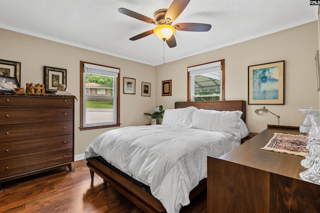 bedroom featuring dark wood-style floors, crown molding, a textured ceiling, a ceiling fan, and baseboards