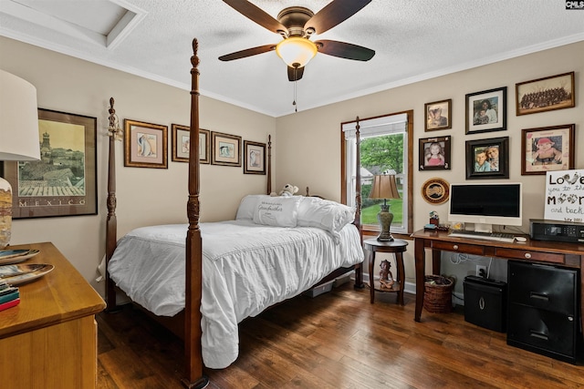 bedroom with dark wood-type flooring, a textured ceiling, ornamental molding, and a ceiling fan