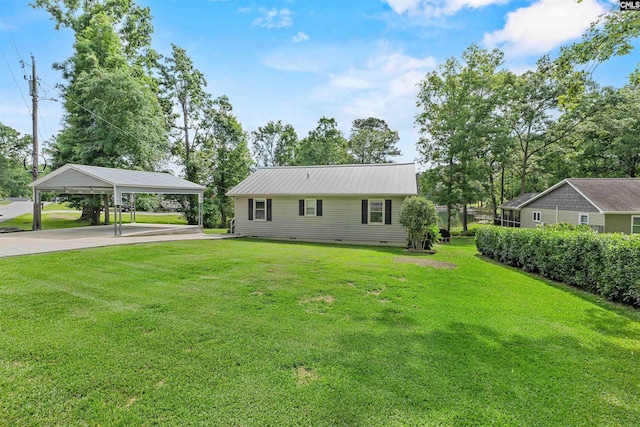 back of house featuring a carport, concrete driveway, crawl space, a lawn, and metal roof