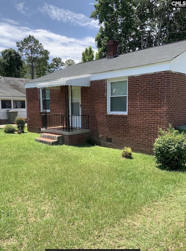 59 Dumont St, Columbia, SC 29201 - view of front facade featuring crawl space, brick siding, a front lawn, and a chimney