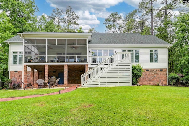 rear view of property featuring a sunroom, stairway, a lawn, and a patio