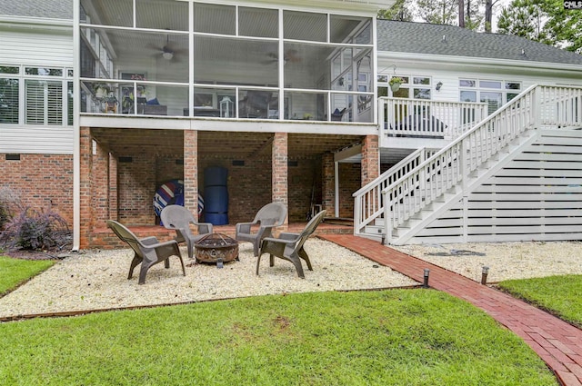 rear view of house featuring a sunroom, a fire pit, a deck, and stairway