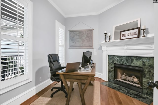 office with wood finished floors, plenty of natural light, a fireplace, crown molding, and baseboards