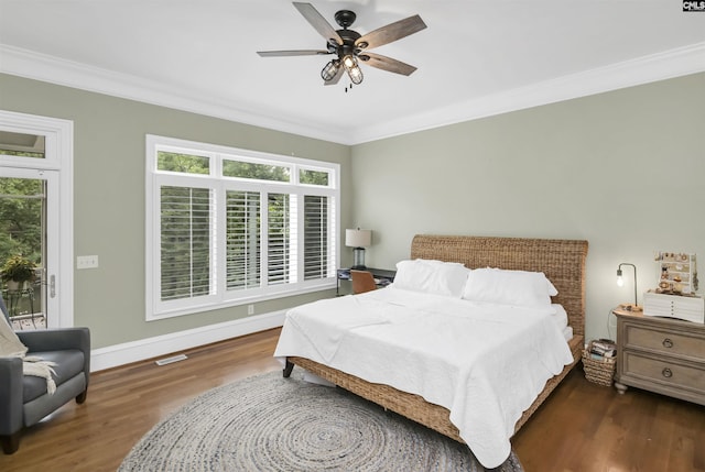 bedroom featuring ornamental molding, wood finished floors, multiple windows, access to exterior, and baseboards