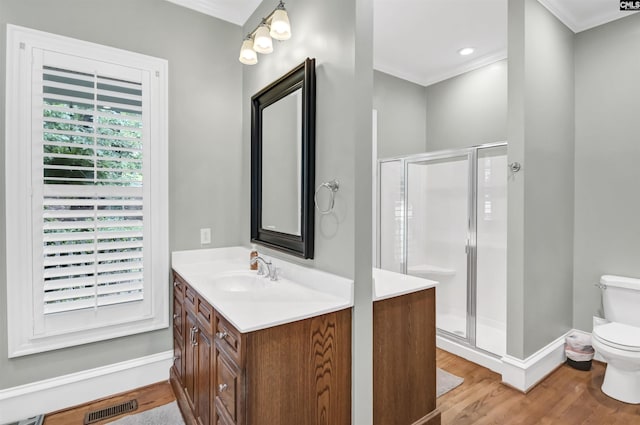 full bath featuring toilet, wood finished floors, crown molding, a stall shower, and vanity