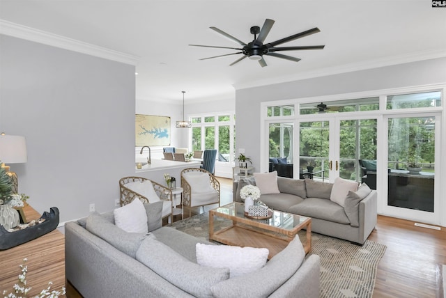 living room with a ceiling fan, ornamental molding, wood finished floors, and french doors