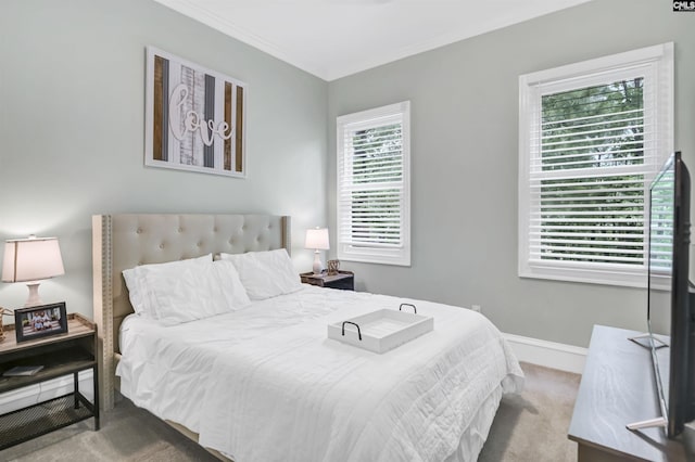 carpeted bedroom with ornamental molding and baseboards