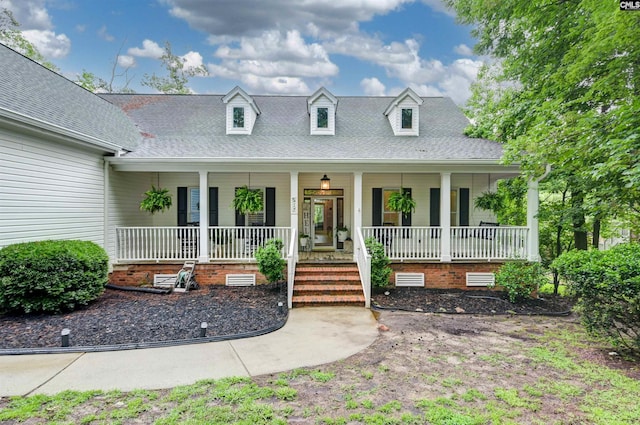 cape cod-style house with a porch, crawl space, and a shingled roof