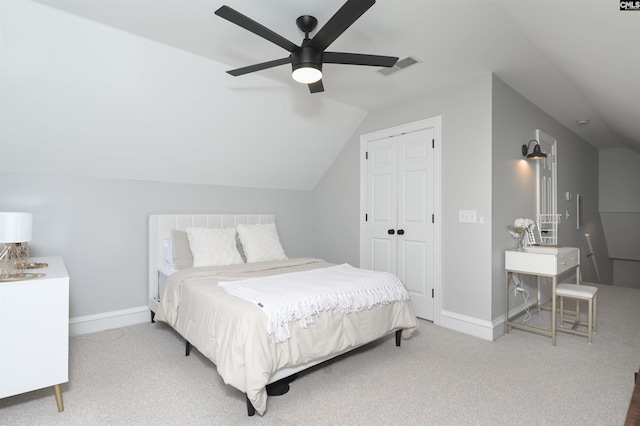 bedroom with carpet floors, lofted ceiling, baseboards, a closet, and ceiling fan