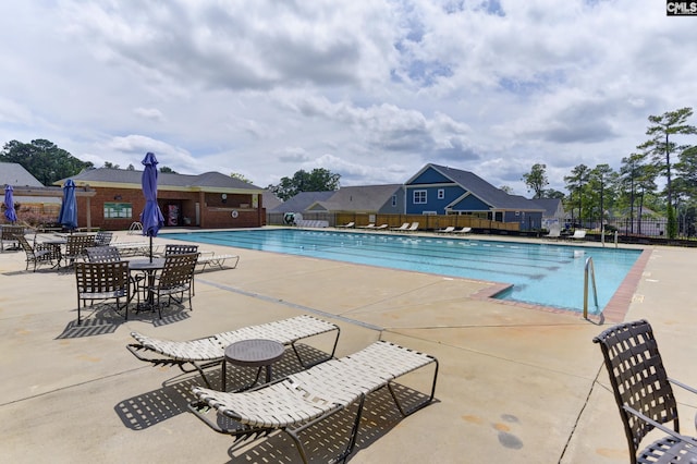 community pool featuring fence and a patio area